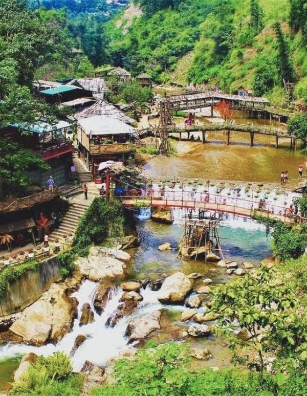 Hanoi Sapa scenic river view with lush greenery and traditional village houses.