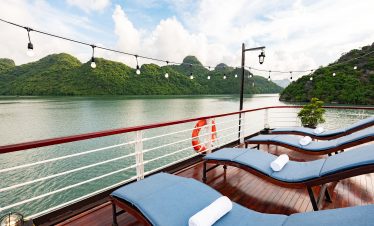Stunning view from a luxury cruise balcony in Halong Bay with lush green islands and calm waters, pe.