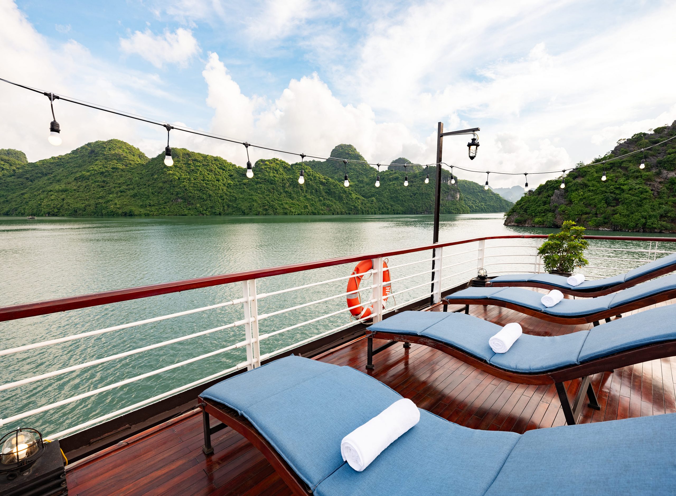 Stunning view from a luxury cruise balcony in Halong Bay with lush green islands and calm waters, pe.