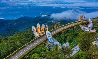 Vietnam Mountain Bridge over lush green forest and misty mountains.