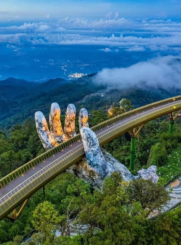 Vietnam Mountain Bridge over lush green forest and misty mountains.