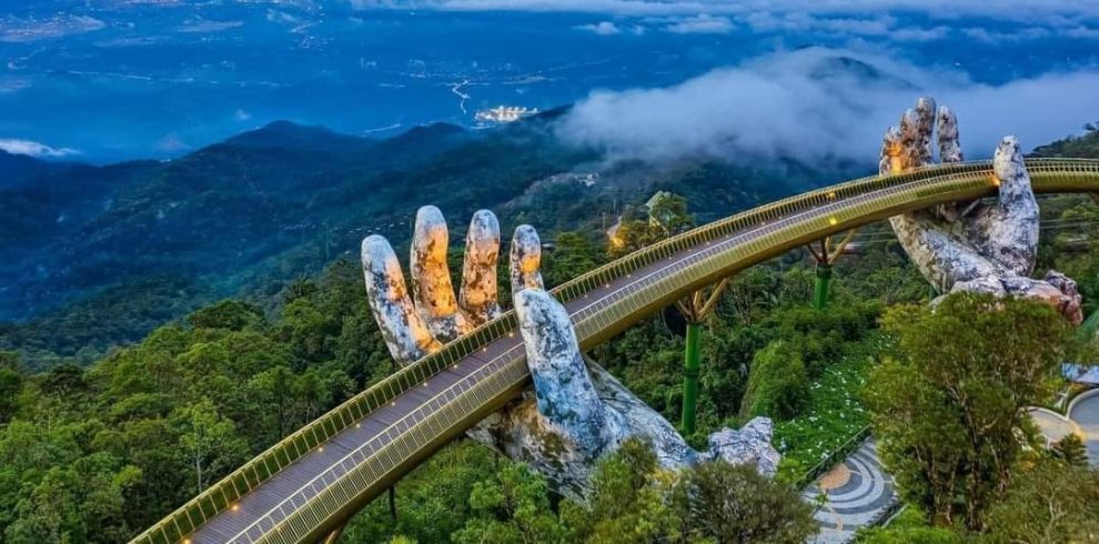 Vietnam Mountain Bridge over lush green forest and misty mountains.