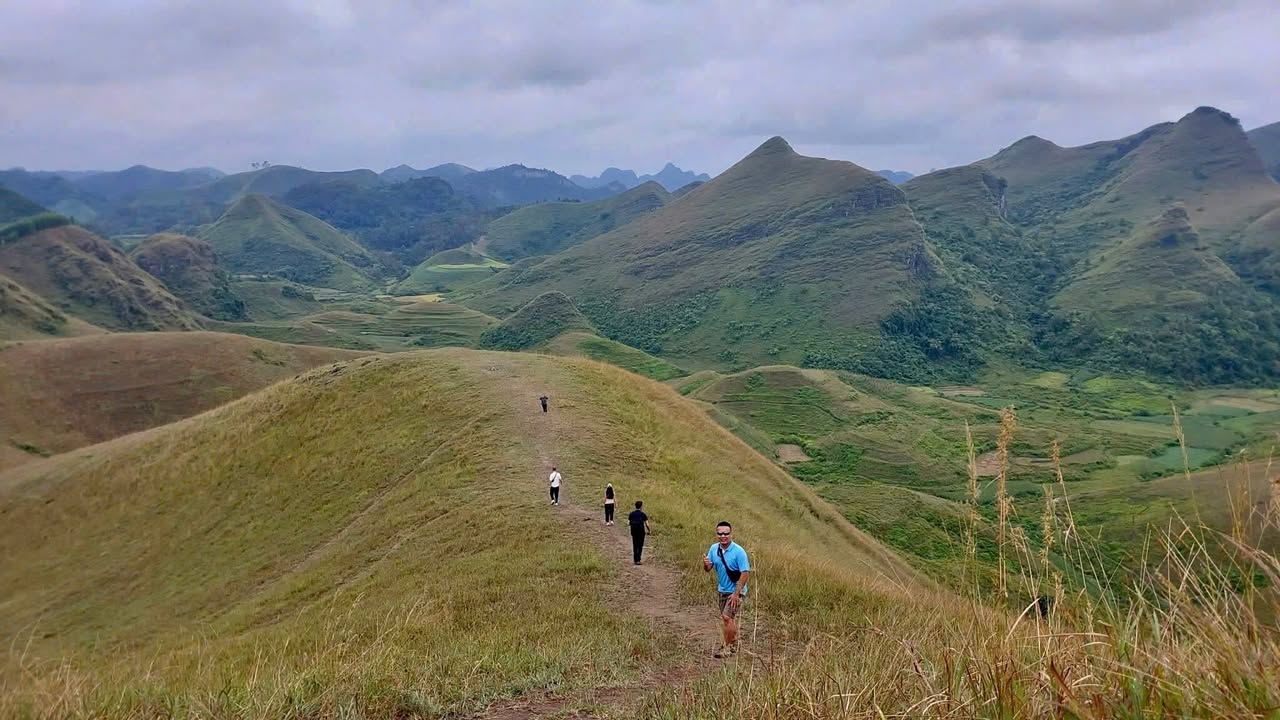 Stunning mountain landscape with hikers exploring lush green hills in Vietnam.