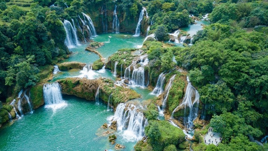 Stunning waterfalls cascading through lush greenery in Ninh Binh, perfect for trekking and nature ex.