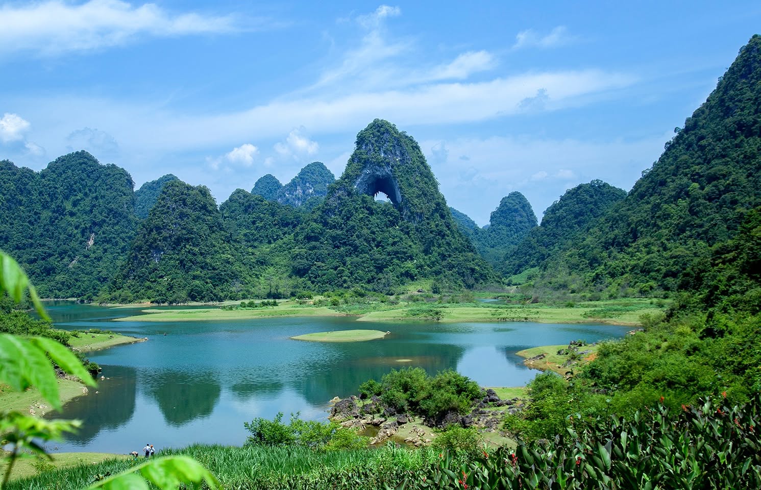 Scenic view of Ban Gioc Waterfall and lush green mountains in Vietnam, perfect for trekking and natu.
