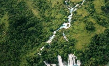 Stunning Ban Gioc Waterfall in Vietnam's lush green landscape, perfect for trekking and nature explo.