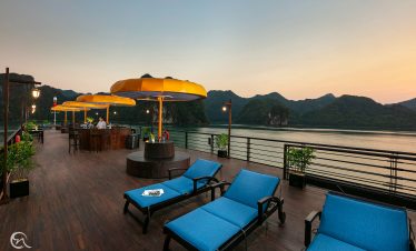 Relaxing outdoor lounge with scenic views of Lan Ha Bay at sunset.