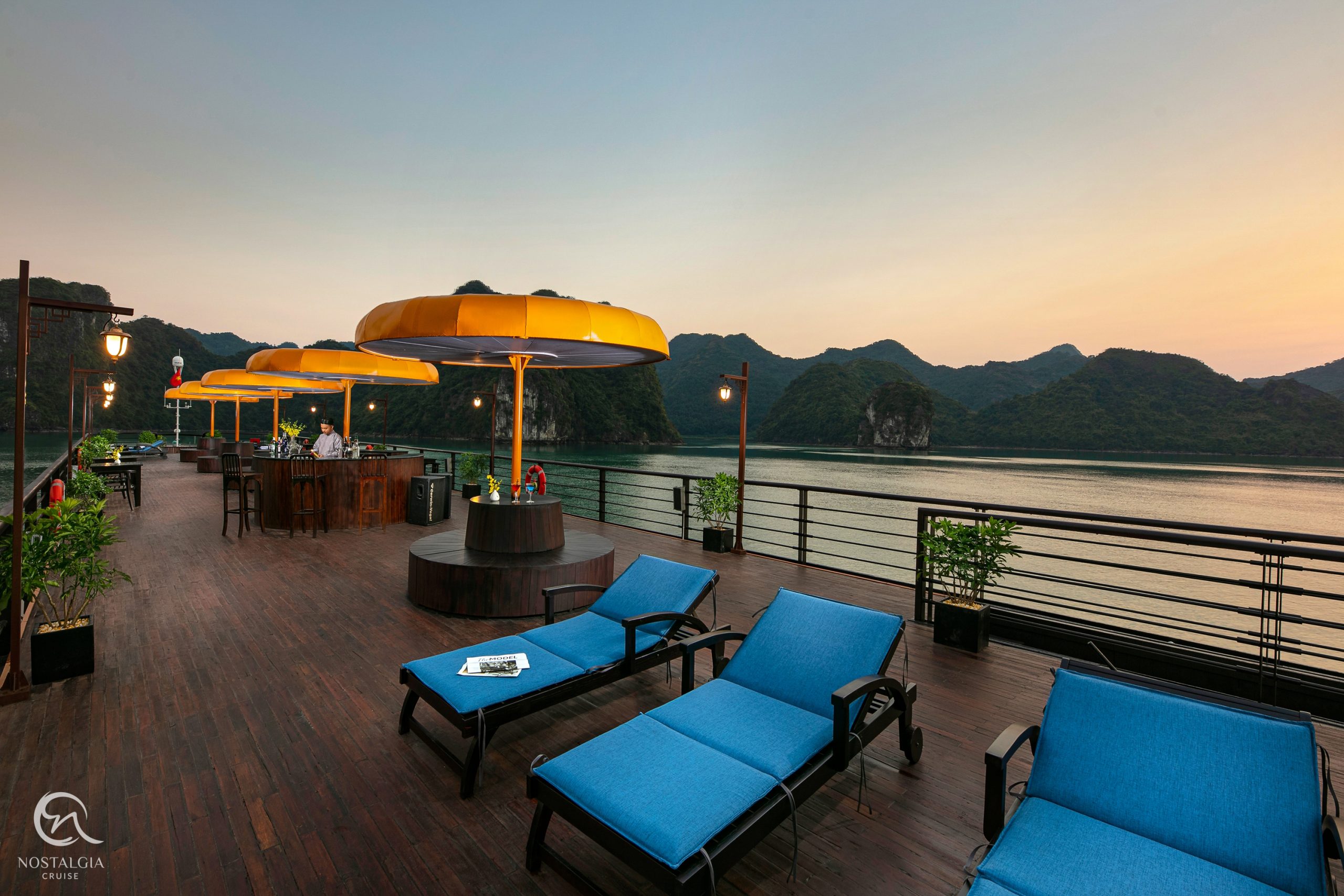 Relaxing outdoor lounge with scenic views of Lan Ha Bay at sunset.