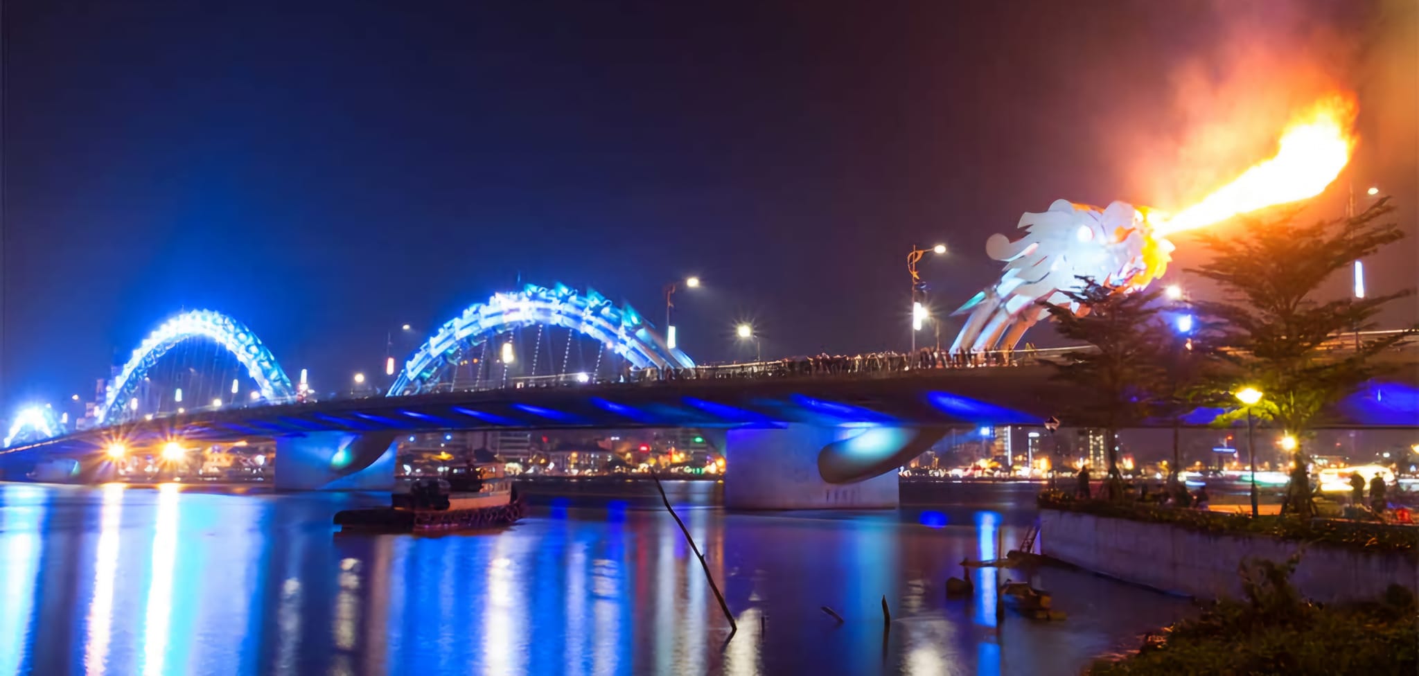 Dragon Bridge illuminated with fiery dragon display at night in Da Nang, Vietnam.