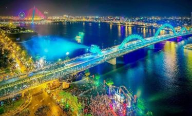 Night cityscape of Ho Chi Minh City with vibrant lights and illuminated bridges.