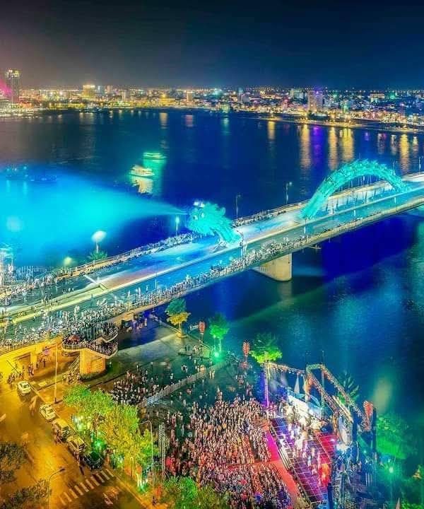 Night cityscape of Ho Chi Minh City with vibrant lights and illuminated bridges.