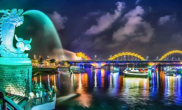 Night cityscape of Ho Chi Minh City with iconic landmarks and vibrant lights reflecting on the river.