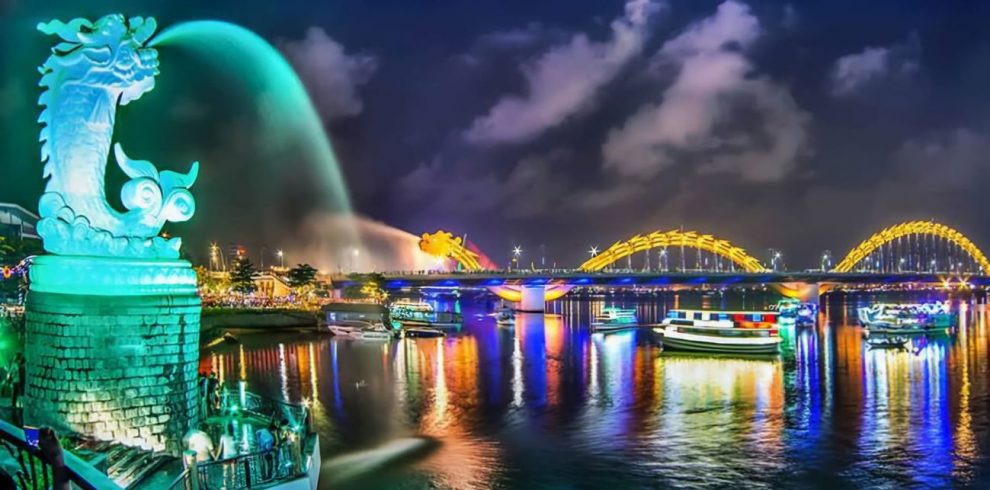 Night cityscape of Ho Chi Minh City with iconic landmarks and vibrant lights reflecting on the river.