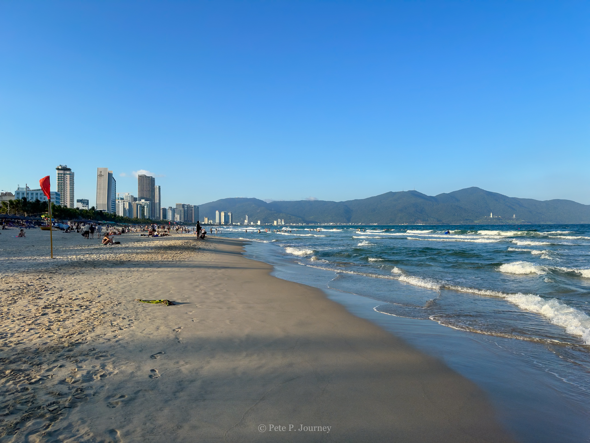 Beach view with city skyline and mountains in the background, perfect for relaxing during your Vietn.