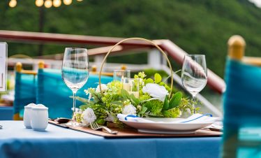 Elegant cruise balcony view of Lan Ha Bay with lush green islands and calm waters, perfect for a rom.