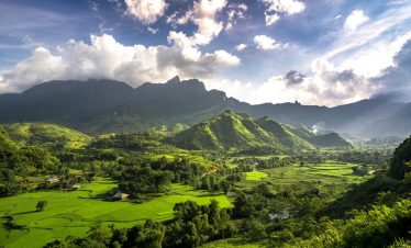 Scenic view of lush green mountains and terraced fields in Ha Giang during daytime.