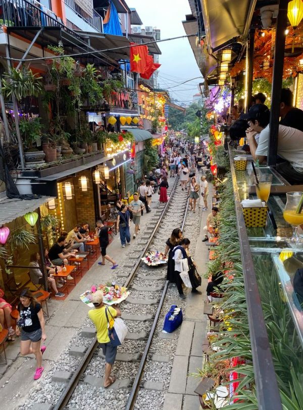 Vietnam street market scene with vibrant lights and bustling crowd.