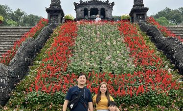 Vietnam cultural heritage site with vibrant flower gardens and historic architecture.