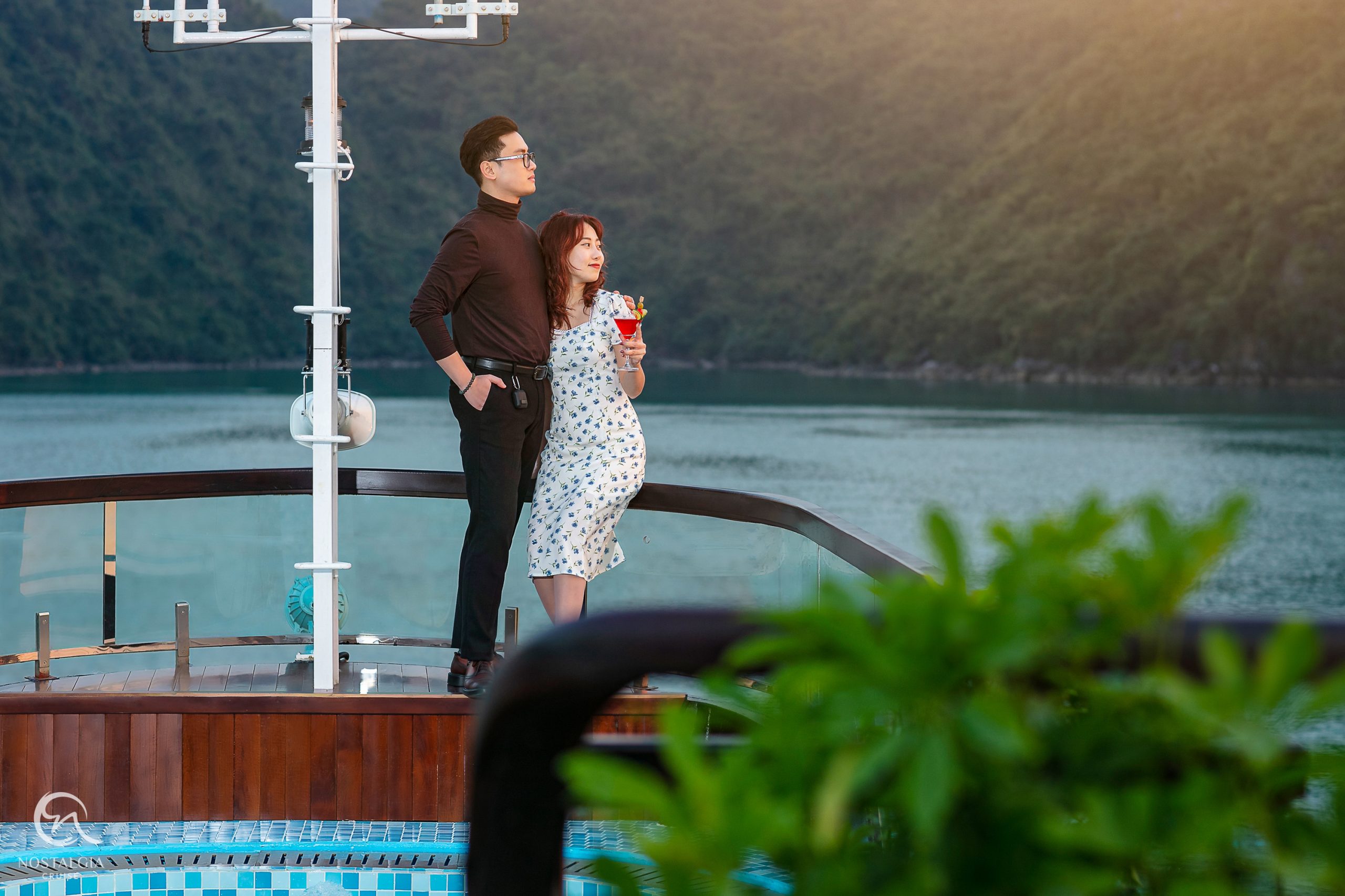 Scenic Lan Ha Bay cruise balcony with couple soaking in breathtaking views, embodying luxury and tra.