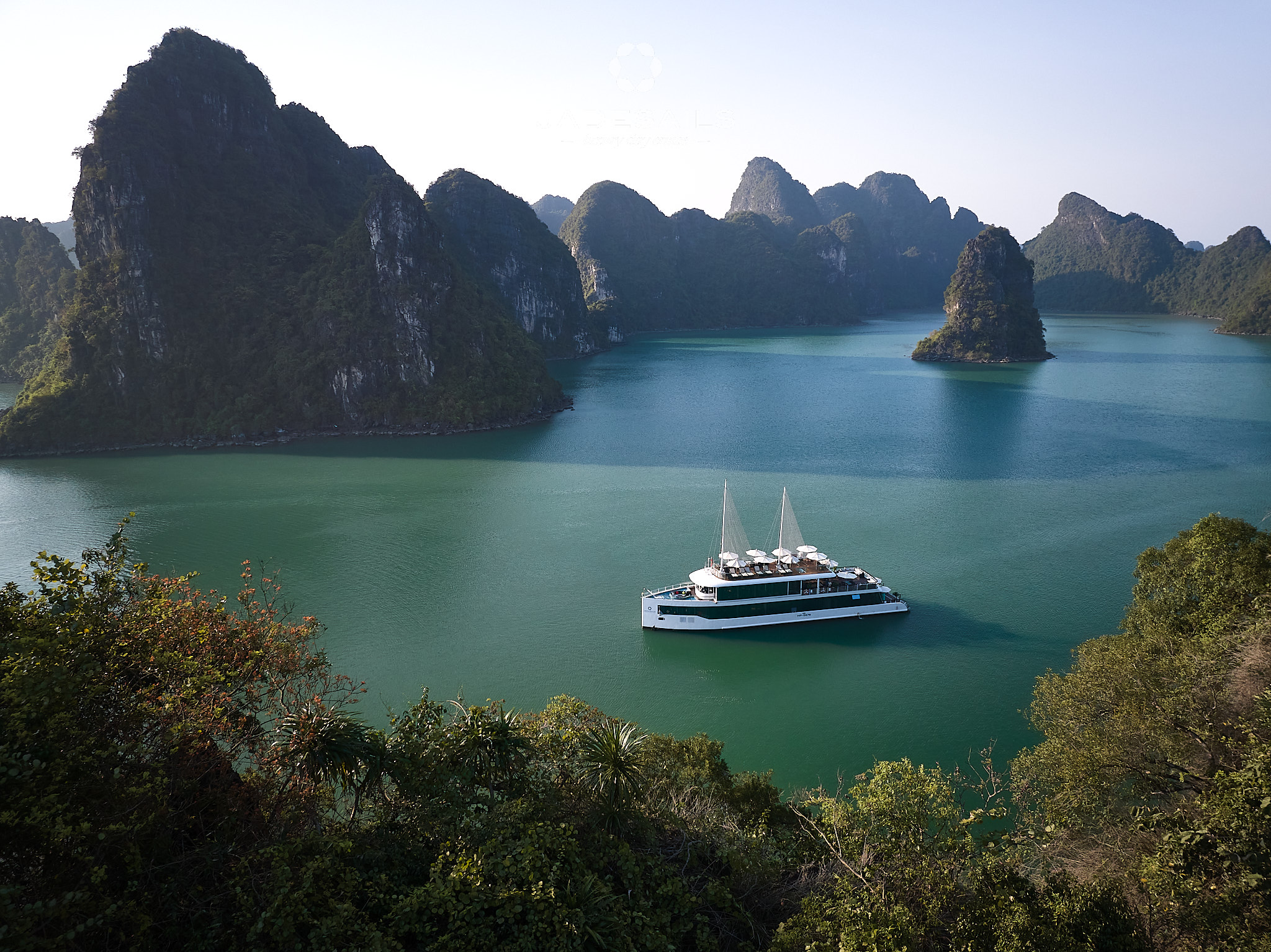 Stunning view of a luxury cruise sailing through Halong Bay's emerald waters surrounded by towering.