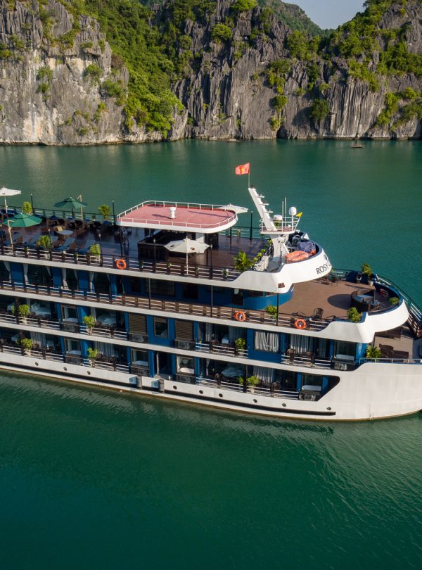 Stunning cruise ship sailing through emerald waters of Lan Ha Bay, Vietnam, offering a luxurious tra.