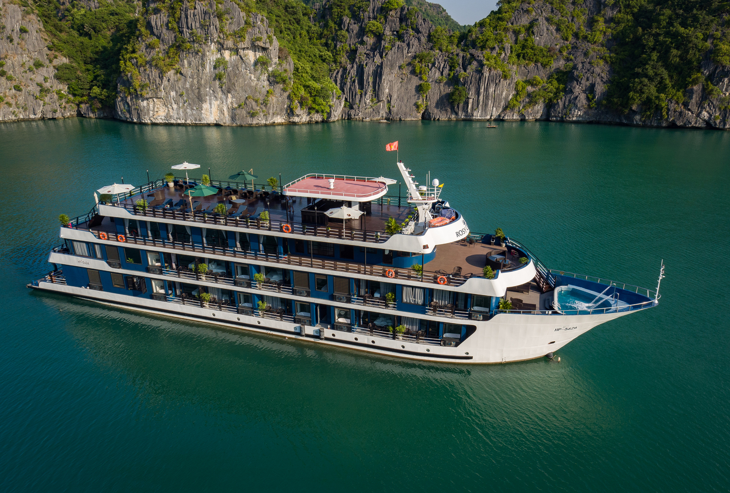 Stunning cruise ship sailing through emerald waters of Lan Ha Bay, Vietnam, offering a luxurious tra.