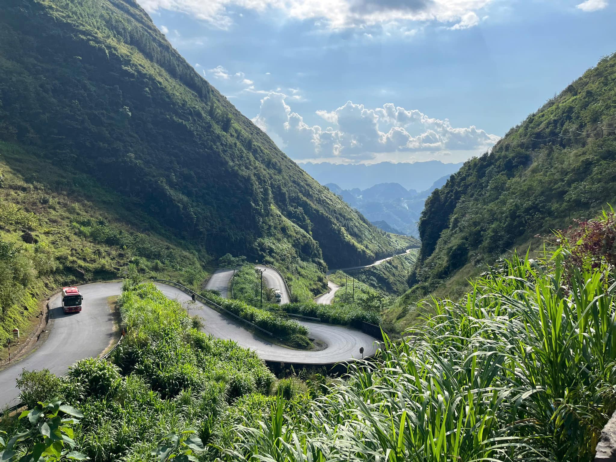Stunning mountain valley with winding road, vibrant greenery, and dramatic peaks, perfect for scenic.