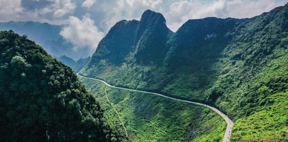 Breathtaking view of Ha Giang mountains with winding road and lush greenery, perfect for adventure t.
