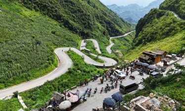 Winding mountain roads in Ha Giang with lush greenery and local village scenes, perfect for adventur.