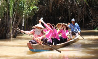 Mekong Delta boat ride with traditional sampans, exploring lush scenery and vibrant local life.