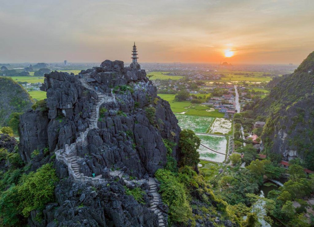 Stunning view of Sapa's mountain landscape with pagoda at sunset, perfect for exploring Vietnam's na.