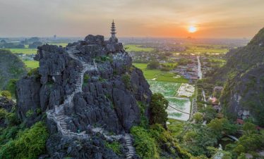 Stunning view of Sapa's mountain landscape with pagoda at sunset, perfect for exploring Vietnam's na.