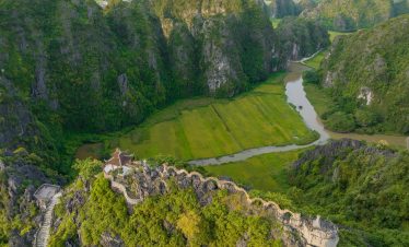 Scenic view of lush green mountains and river in Sapa, Vietnam, perfect for trekking adventures.