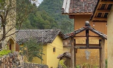 Charming village scene in Sapa with traditional houses and lush mountain backdrop, perfect for trekk.