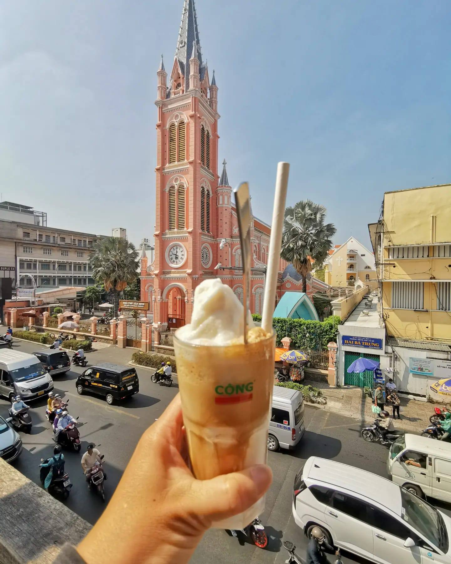 Ice cream drink in hand with vibrant street scene and church in background, capturing local flavor a.