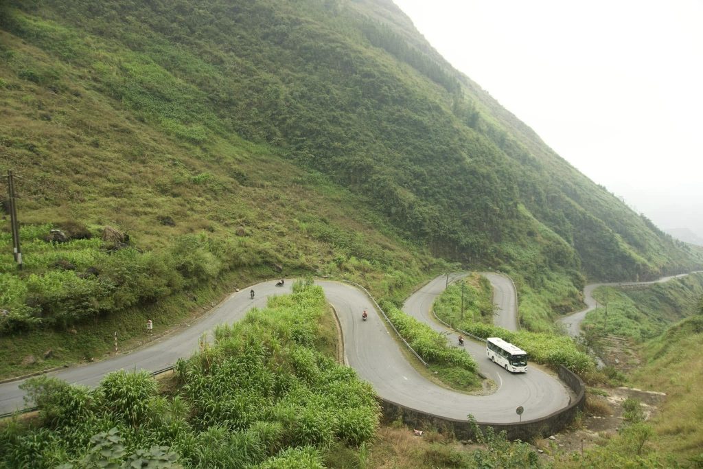 Scenic winding road through lush green mountains in Ha Giang, perfect for adventure and exploration.
