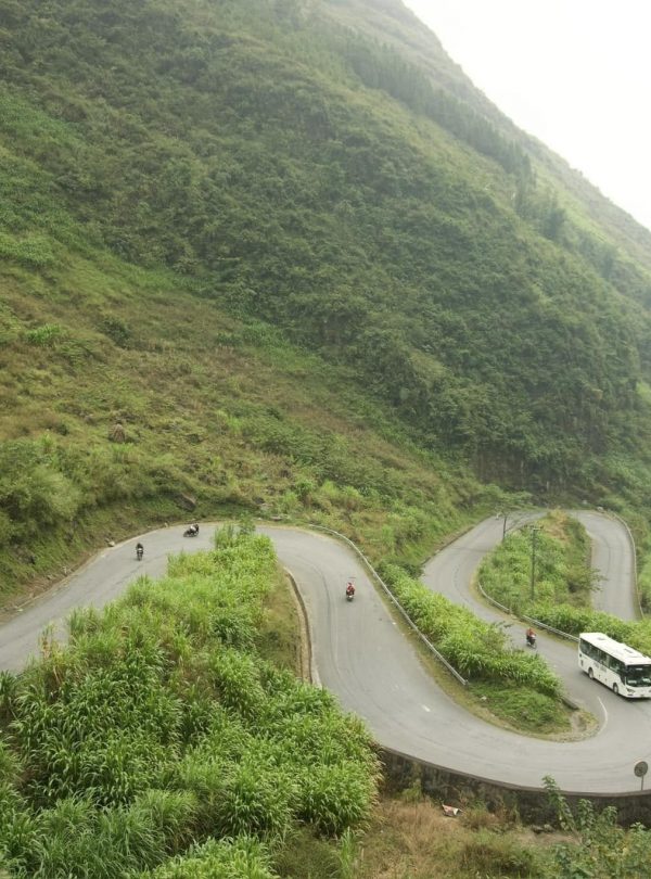 Scenic winding road through lush green mountains in Ha Giang, perfect for adventure and exploration.