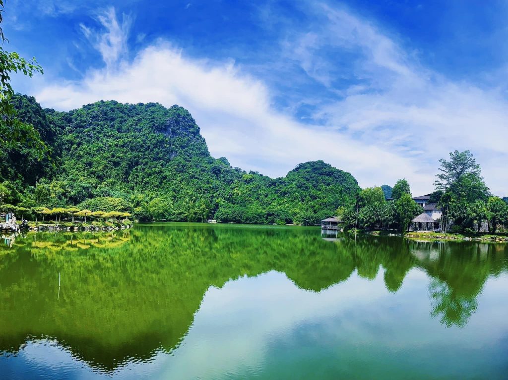 Scenic view of lush green mountains and tranquil lake in Ninh Binh, perfect for relaxing and explori.