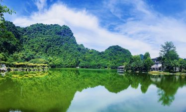 Scenic view of lush green mountains and tranquil lake in Ninh Binh, perfect for relaxing and explori.