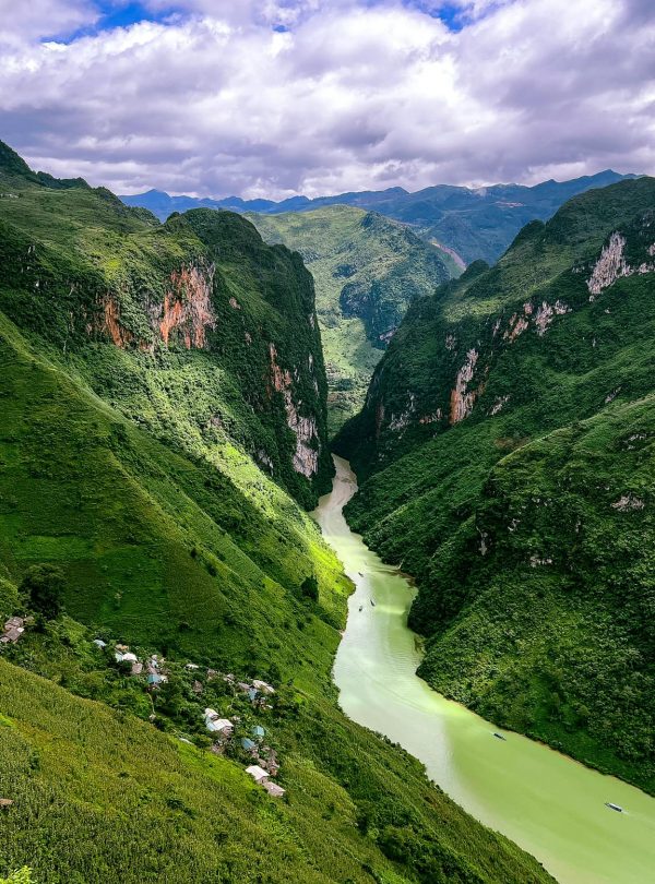 Stunning view of lush green valleys and winding river in Vietnam, perfect for trekking and nature ex.
