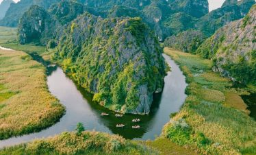 Scenic view of lush green mountains and winding river in Ninh Binh during a trekking adventure.