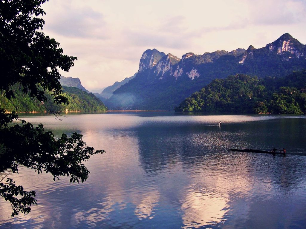 Serene river scene with towering mountains and tranquil waters, perfect for kayaking and exploring V.