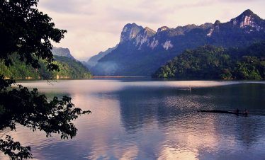 Serene river scene with towering mountains and tranquil waters, perfect for kayaking and exploring V.