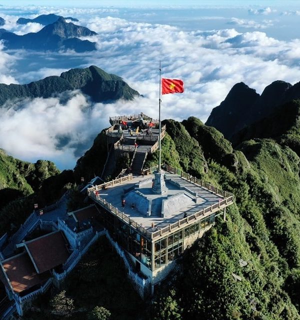 Spectacular view from Fansipan peak showcasing lush green mountains and clouds, perfect for trekking.