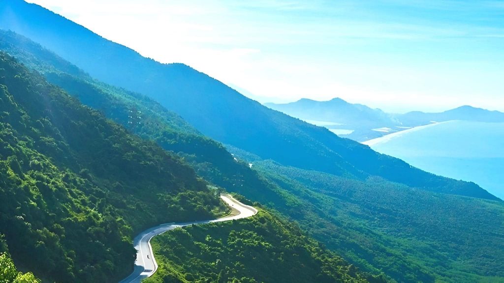 Breathtaking mountain scenery with lush greenery and winding road, perfect for trekking and adventur.
