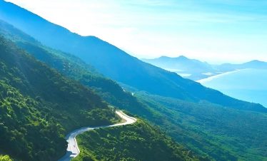 Breathtaking mountain scenery with lush greenery and winding road, perfect for trekking and adventur.