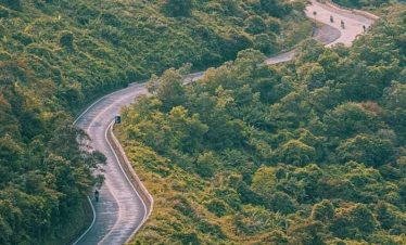 Winding mountain road surrounded by lush greenery, perfect for scenic drives and exploring Vietnam’s.