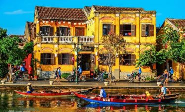 Colorful riverside street in Hue with traditional architecture and local life.