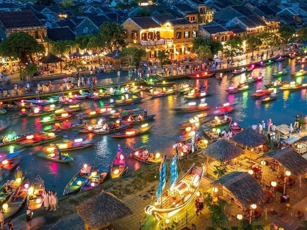 Vibrant night scene of colorful boats on the Thu Bon River in Hoi An, showcasing a lively and romant.