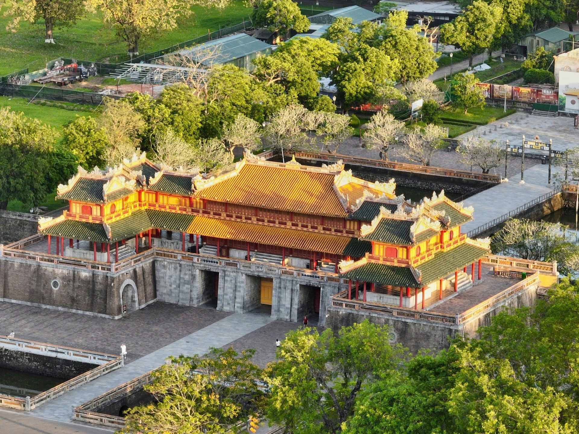 Aerial view of a historic temple with vibrant red and yellow accents amidst greenery in Hue.